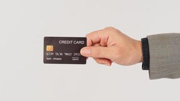 un' mano è Tenere nero credito carte e indossare completo da uomo su bianca sfondo. foto