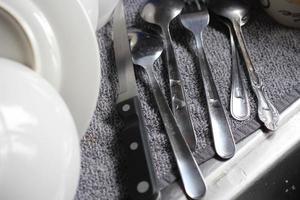 cucchiai, fissaggi, coltelli e piatti siamo posto in giro il Lavello dopo lavaggio. foto
