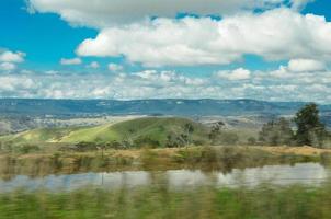 bellissimo verde collina Visualizza di Australia campagna con nuvoloso cielo. foto