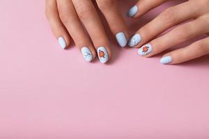 bandiera con femmina mani con inverno neve manicure con adesivi sotto un' Opaco superiore su rosa sfondo foto