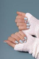 femmina mani con inverno neve manicure con adesivi sotto un' Opaco superiore foto