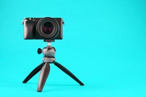 professionale telecamera su un' treppiedi, su un' blu sfondo. disco video e fotografie per il tuo blog o rapporto.