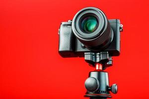 professionale telecamera su un' treppiedi, su un' rosso sfondo. disco video e fotografie per il tuo blog, reportage