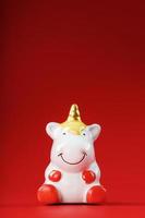 unicorno figurina su un' rosso sfondo con gratuito spazio. foto