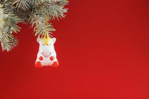 unicorno figurina su un' Natale albero su un' rosso sfondo, gratuito spazio per testo. foto