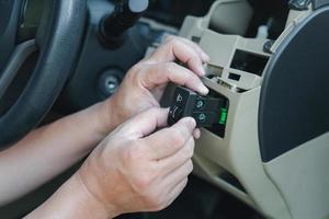 vicino su mano tecnico controllo auto faro interruttore per Manutenzione per verificare quello il scorta parti bisogno per essere sostituito nel servizio negozio foto