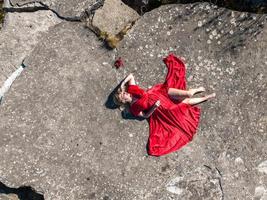 aereo Visualizza su ragazza nel rosso vestito su roccia o calcestruzzo rovinato struttura foto