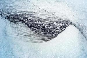 nero olio sentieri guardare piace un' ala su un' chiaro bianca neve. ecologico concetto. foto