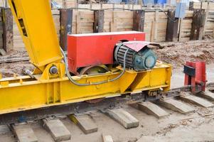 grande ferro metallo giallo supporti su rotaie con ruote con un induzione il motore di un' grande costruzione stazionario industriale potente cavalletto gru di un' ponte genere foto