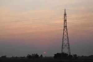 alto voltaggio palo, alto voltaggio Torre con cielo tramonto sfondo. foto