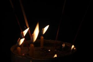 candele ardente brillantemente su nero sfondo foto