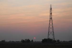 alto voltaggio palo, alto voltaggio Torre con cielo tramonto sfondo. foto