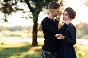 allegro giovane donna e uomo siamo abbracciare all'aperto nel estate parco. incontri e romantico vacanza. coppia nel amore delicatamente guardare a ogni altro su soleggiato giorno. san valentino giorno. foto