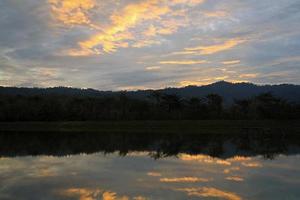 silhouette di montagna e riflessione di nube nel lago o fiume con foresta e cielo sfondo a tramonto o Alba volta. bellezza nel natura e naturale sfondo. foto