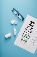 oftalmico Accessori bicchieri e lenti a contatto con un occhio test grafico per visione correzione su un' blu sfondo foto