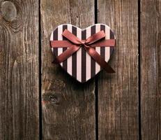 confezione regalo San Valentino a forma di cuore su piatti di legno. foto