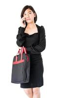 donna trasporto un' nero shopping Borsa utilizzando cellulare shopping in linea foto