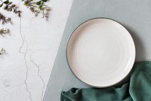 vuoto ceramica piatto, eucalipto rami e tessuto su un' due toni sfondo. eco concetto. superiore Visualizza foto