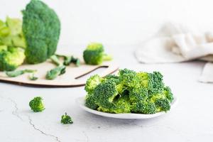 pezzi di crudo broccoli su un' piatto su un' leggero tavolo. foto