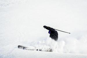 dinamico immagine di un' sciatore su il pista nel Alpi. donna sciatore nel il morbido neve. attivo inverno vacanze, sciare discesa nel soleggiato giorno.sci cavalcate su il traccia con turbinii di fresco neve foto