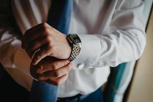 uomo mettendo orologio su mano, sposo ottenere pronto nel il mattina foto