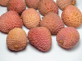 lychee su il tavolo. Cinese prugna su un' bianca sfondo. maturo frutta a partire dal Asia. delizioso Prodotto. foto