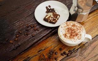 caldo cappuccino nel bianca tazza con di legno sfondo, caffè è un' popolare bevanda tutti al di sopra di il mondo. foto