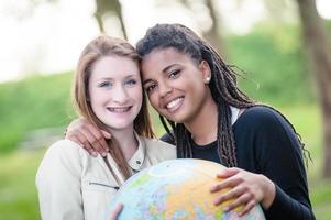 coppia multirazziale di amici in possesso di mappa del globo