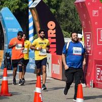 nuovo delhi, India - ottobre 16 2022 - vedanta delhi metà maratona gara dopo covid nel quale maratona partecipanti di per attraversare il finire linea, delhi metà maratona 2022 foto