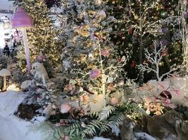 nuovo anno decorazione Accessori. festivo ghirlande, regali, i regali e luci vicino il Natale albero. preparazione per festeggiare foto