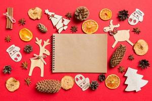 superiore Visualizza di taccuino, rosso sfondo decorato con festivo giocattoli e Natale simboli renne e nuovo anno alberi. vacanza concetto foto