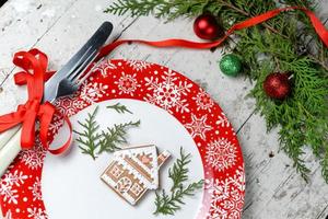 decorazioni natalizie per la tavola con piatto rosso e posate foto