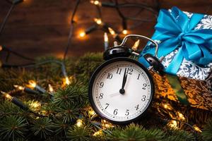 albero di natale, regali, luci e orologio sulla parete in legno
