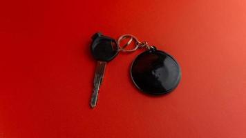 nero motociclo chiave con nero il giro portachiavi su rosso sfondo. portachiavi modello per design foto