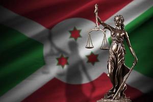 burundi bandiera con statua di signora giustizia e giudiziario bilancia nel buio camera. concetto di giudizio e punizione foto