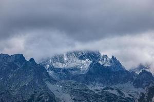 tatra alto montagna passaggio nel drammatico atmosfera. nuvoloso Cloudscape con nevoso montagna picco. astratto alto montagna nuvoloso cielo sfondo, viaggio avventura. estremo escursionismo, ricreativo panoramico foto