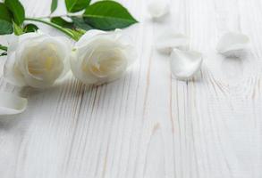 rose bianche su un tavolo di legno foto
