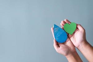 mani Tenere verde cuore e acqua far cadere concetto di Salva acqua Salva il mondo. foto