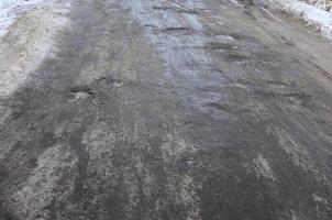 danneggiato asfalto strada con buche causato di congelamento e scongelamento cicli durante il inverno. povero strada foto