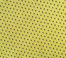 vicino su di giallo poliestere nylon giallo abbigliamento sportivo pantaloncini per creato un' strutturato sfondo foto