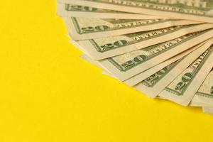 grande quantità di vecchio venti dollaro fatture su giallo sfondo. i soldi guadagni, giorno di paga o imposta pagare periodo foto