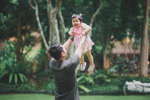 asiatico godere contento padre papà Tenere il suo figlia e avendo bene tempo nel autunno parco. concetto di famiglia. padre e bambino figlia. contento famiglia. foto