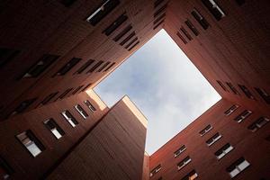 mattone grattacielo nuovo piazza Casa su un' blu cielo sfondo. Visualizza a partire dal il cortile per il superiore di il cielo. lusso alloggiamento e uffici per opera. foto