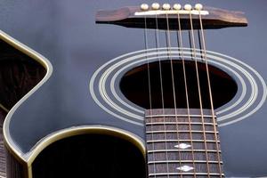 acustico nero chitarra su di legno tavolo e bianca sfondo. foto