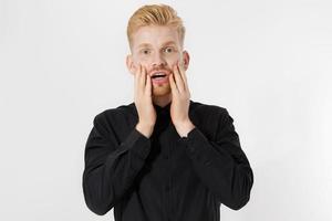 eccitato sorpreso shock giovane isolato su sfondo grigio. ragazzo dai capelli rossi felice con la barba rossa in camicia nera alla moda. concetto di successo e superamento dell'esame. copia spazio. primo piano dell'espressione del viso. foto