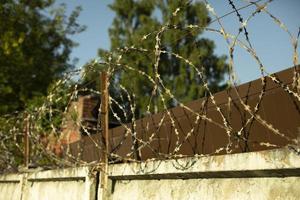 spinato filo su recinzione. vecchio recinzione. bianca calcestruzzo lastra. foto