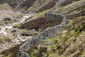 asciutto impilati pietra parete con il colline di il yorkshire Dales unito regno nel il sfondo foto