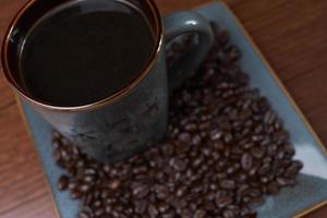 una tazza di caffè con chicchi di caffè foto