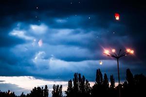 nel il sera, a tramonto, persone con loro parenti e amici lanciare tradizionale lanterne. foto