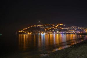 meraviglioso riflessione di notte su il mare e città mare Visualizza foto